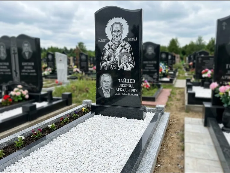 Памятник с гравировкой иконы: стела с крестообразным навершием — икона в резной рамке-киоте, газон без ограды, стриженая трава, работа «Раевская» в Барнауле