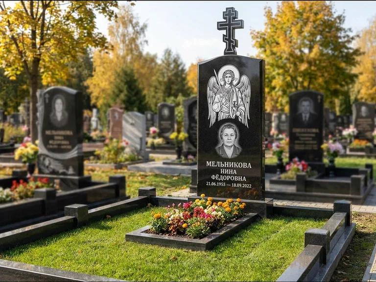 Памятник с гравировкой иконы: округлая стела-медальон с ликом — гравировка Богородицы «Семистрельная», луговые травы и полевые цветы за участком, работа «Гущин» в Барнауле