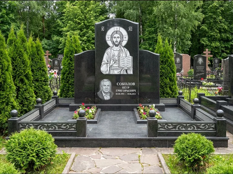 Памятник с гравировкой иконы: широкая горизонтальная лежачая плита-стела — икона в резной рамке-киоте, серая гравийная отсыпка с бордюром, работа «Богданова» в Барнауле