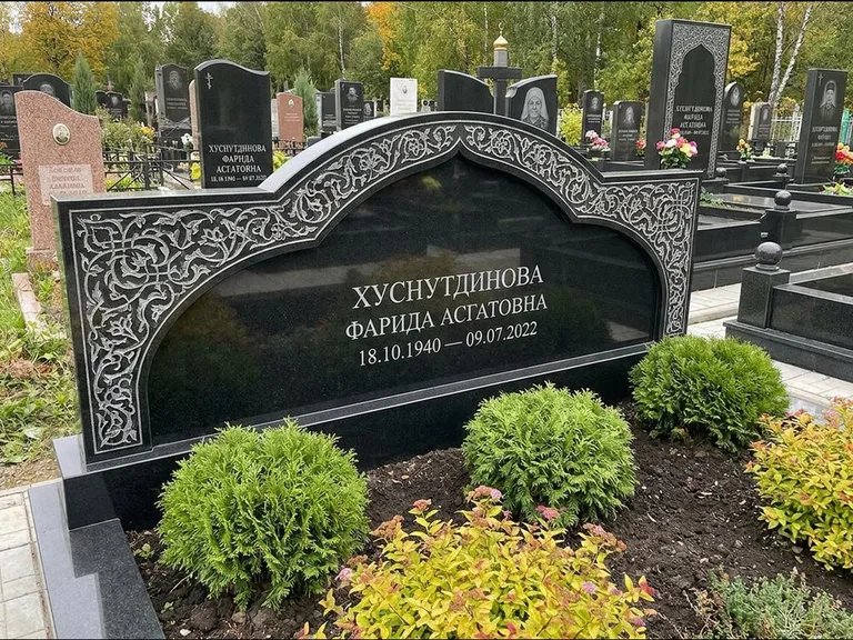 Мусульманский памятник: вытянутая горизонтальная семейная стела с аркой — белая гравировка силуэта мечети с минаретами, участок с декоративными кустами, работа «Зарипова» в Барнауле