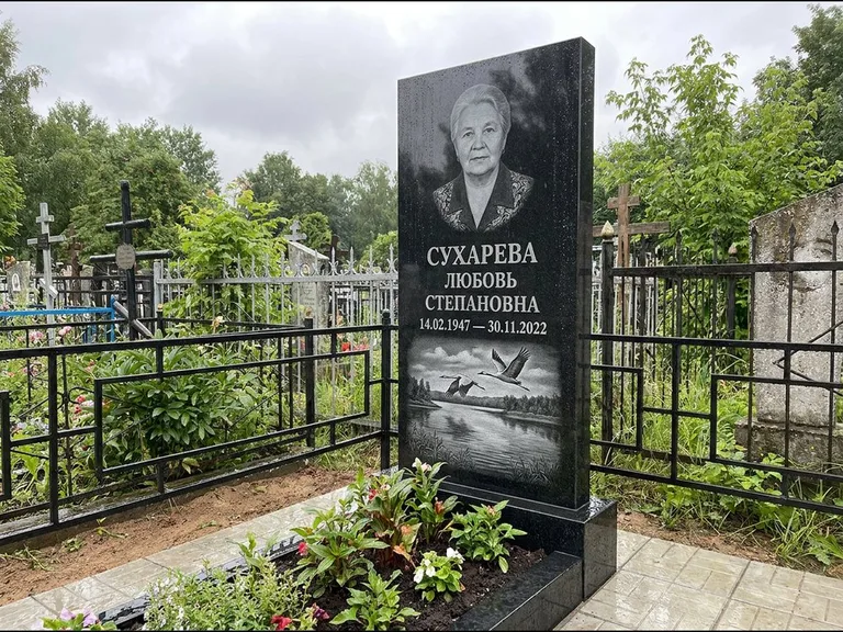 Памятник с гравировкой журавлей — гравировка пары журавлей над гладью озера в нижней части, работа «Сухарева» в Барнауле
